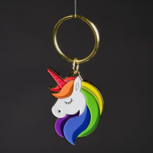 Colorful unicorn keychain on dark background.