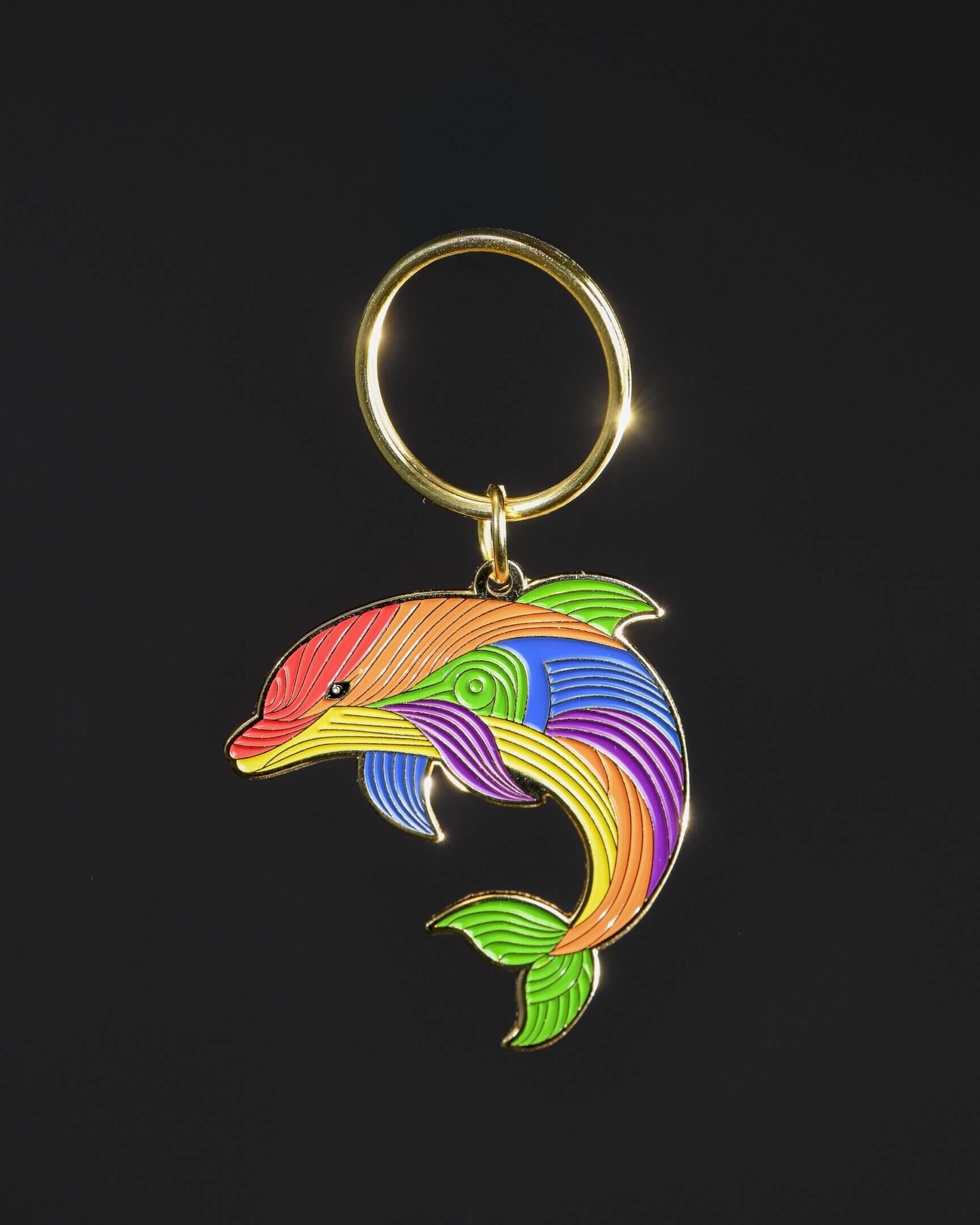 Colorful dolphin keychain on black background.