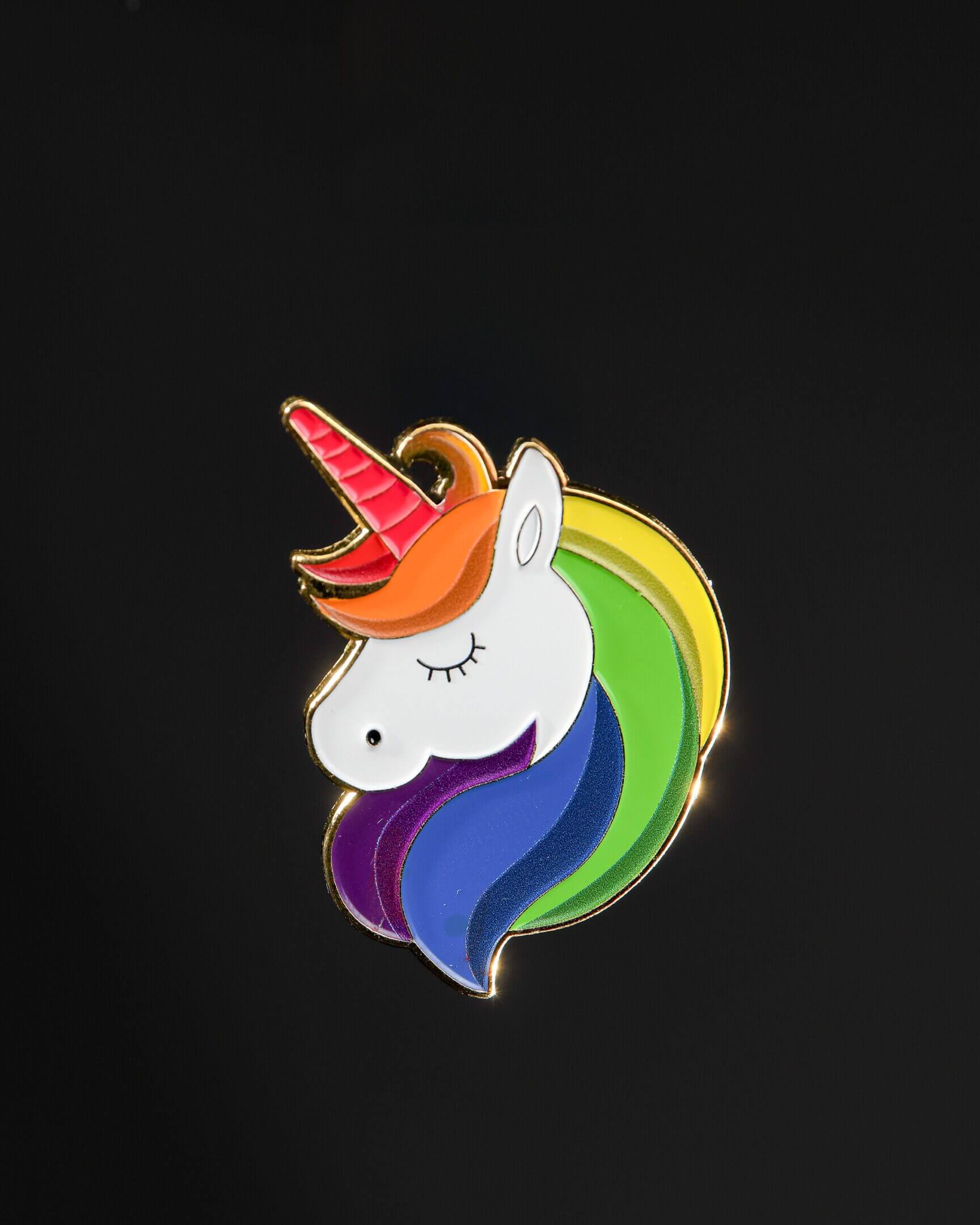 Unicorn pin with rainbow mane on black.