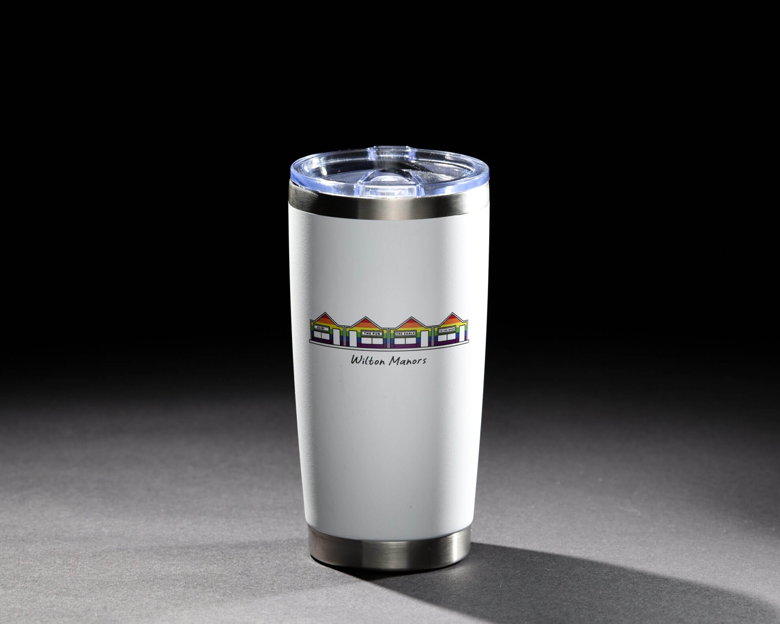 A white insulated tumbler with a mountain-themed logo on a dark background.